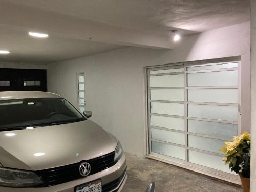 a garage with a car parked next to a garage door at Depa wifi en corredor de balnearios in Ixmiquilpan
