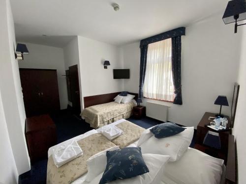 ザコパネにあるHotel Patria Zakopane Centrumのリビングルーム(ベッド2台、ソファ付)