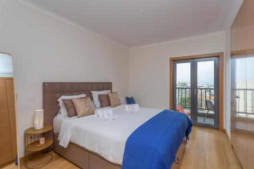ein Schlafzimmer mit einem großen Bett und einem Balkon in der Unterkunft BeGuest Vasco da Gama Apartment in Lissabon