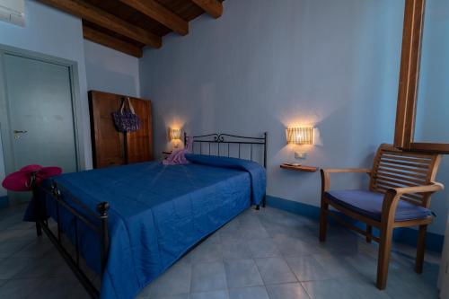 a bedroom with a blue bed and a chair at Solares Case Vacanze in Ustica