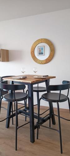 une table en bois avec deux chaises et un miroir dans l'établissement Appartement Vue Mer- Remblai les sables d'olonne - La Clé Chaumoise, à Les Sables-dʼOlonne