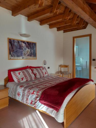 a bedroom with a large bed with red pillows at Alloggio Turistico Bufera in Roana