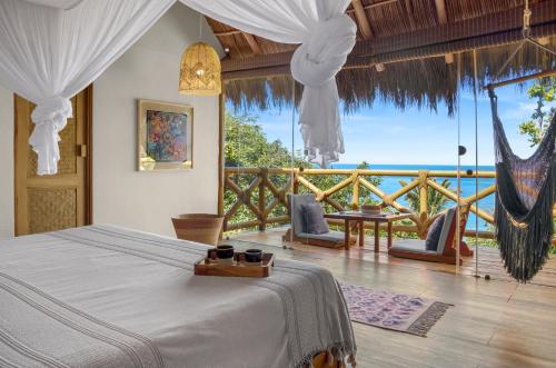 a bedroom with a bed and a view of the ocean at Xinalani Retreat Mexico in Qumiste