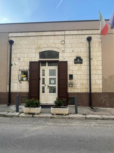 een deur van een gebouw met twee planten ervoor bij Antica Mateola in Matera