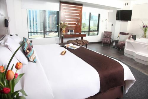 Schlafzimmer mit einem weißen Bett und einem großen Fenster in der Unterkunft Hotel Rivera Inn in Lima