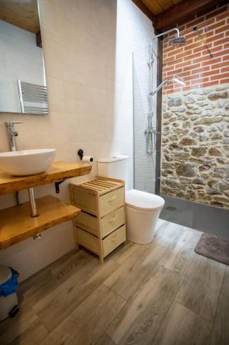 a bathroom with a sink and a toilet and a shower at La casita del abuelo in Galizano