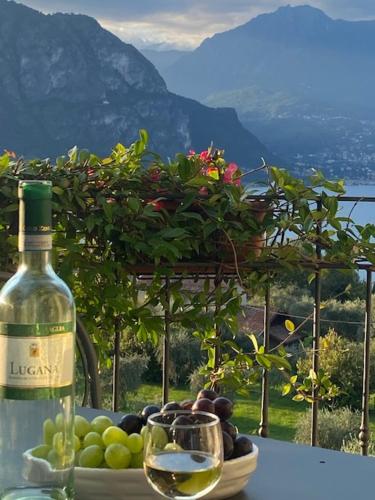 a bottle of wine sitting on a table with a bowl of grapes at Il Poggio Di Bellagio in Bellagio