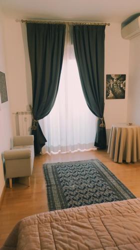 um quarto com uma cama, uma cadeira e uma janela em Lovely Suite accogliente appartamento tra Policlinico e Piazza Bologna em Roma