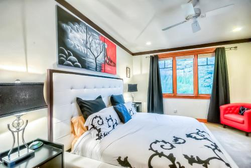 a bedroom with a large bed and a red chair at Villa BG in Steamboat Springs