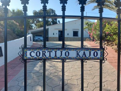 een poort met een bord dat Corolla kaito leest bij Cortijo Kajo in Torrox
