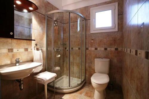 a bathroom with a shower and a toilet and a sink at Apartments Corfu Sun Sea Side in Benitses