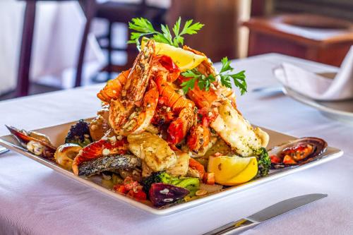 a plate of food with shrimp and vegetables on a table at Aruanã Eco Praia Hotel in Aracaju