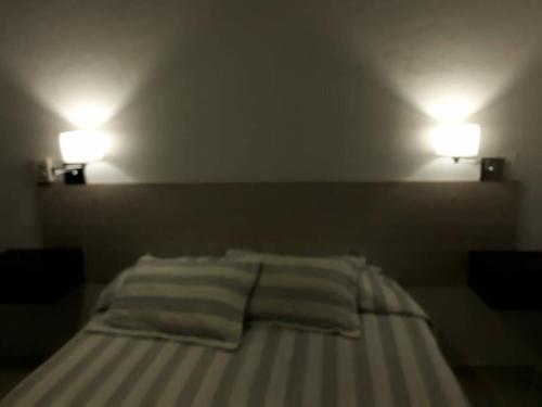 1 cama en una habitación con 2 luces en la pared en Alquiler en San Rafael en San Rafael