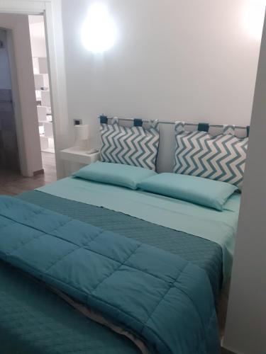 ein Bett mit blauer Decke in einem Schlafzimmer in der Unterkunft Villa Cecilia in Montallegro