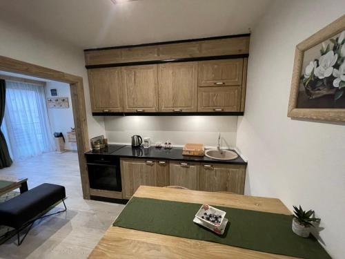 a kitchen with wooden cabinets and a table in a room at Apartman Anna Budva in Budva