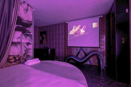 ein lila Schlafzimmer mit einem Bett und einem TV in der Unterkunft Homstay vinhomes oceanpark in Hanoi