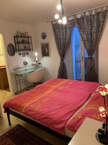 a bedroom with a bed and a desk and a window at Ferienhaus, Rustico Auf Burg in Locarno