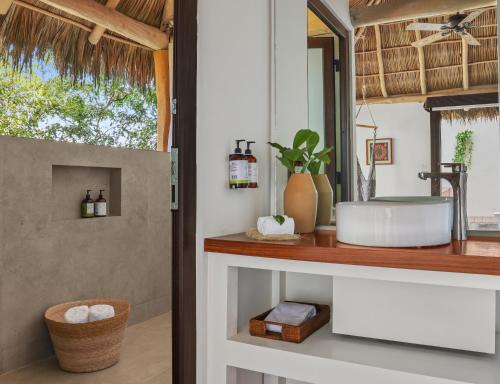 a bathroom with a sink and a mirror at Xinalani Retreat Mexico in Qumiste