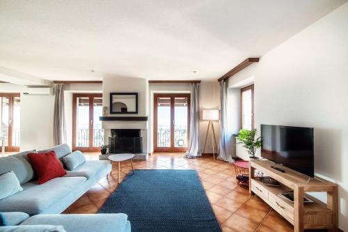 - un salon avec un canapé et une télévision dans l'établissement Lilia Apartment by Quokka 360 - large flat with panoramic view of Locarno, à Gordola