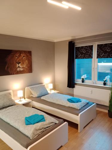 een slaapkamer met 2 bedden en een leeuwenfoto aan de muur bij Stadtnah an der Förde 7 HH L 1OG in Flensburg