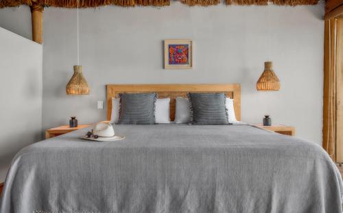 a bedroom with a bed with a gray bedspread at Xinalani Retreat Mexico in Qumiste
