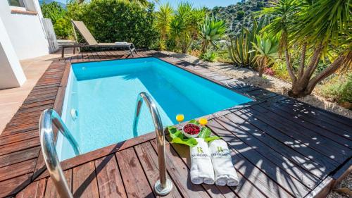 a swimming pool on a deck next to a house at Casa Holly Comares by Ruralidays in Comares