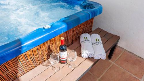 a table with wine glasses and a swimming pool at Casa Holly Comares by Ruralidays in Comares