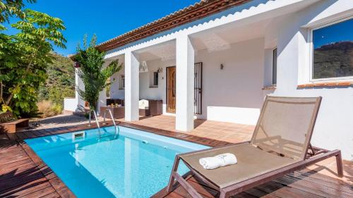 a villa with a swimming pool and a chair at Casa Holly Comares by Ruralidays in Comares