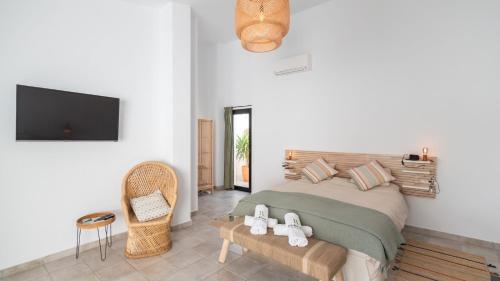 um quarto com uma cama, uma televisão e uma cadeira em El Cine Canillas de Albaida by Ruralidays em Canillas de Albaida