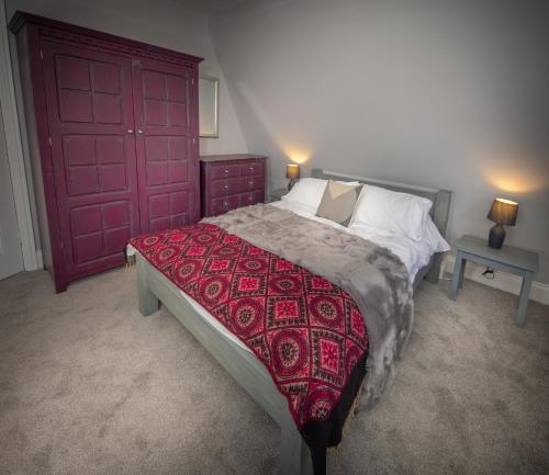a bedroom with a large bed with a red door at Loft Apartment, Keswick in Keswick