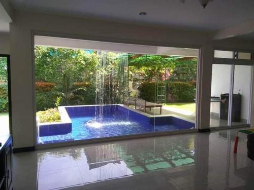 a large swimming pool with a fountain in a house at Angeles Pool Villa in Angeles
