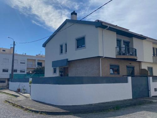 una casa blanca con una valla delante en Barrosa House, en Vila Praia de Âncora