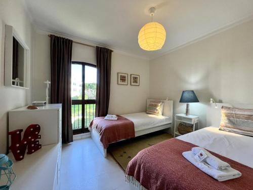Habitación de hotel con 2 camas y ventana en Vilamoura Brightness With Pool by Homing en Vilamoura