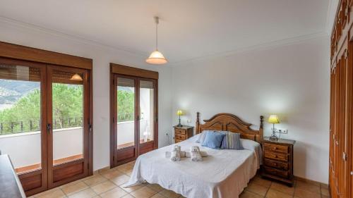 1 dormitorio con 1 cama y balcón con ventanas en Lake view villa Iznájar by Ruralidays en Iznájar
