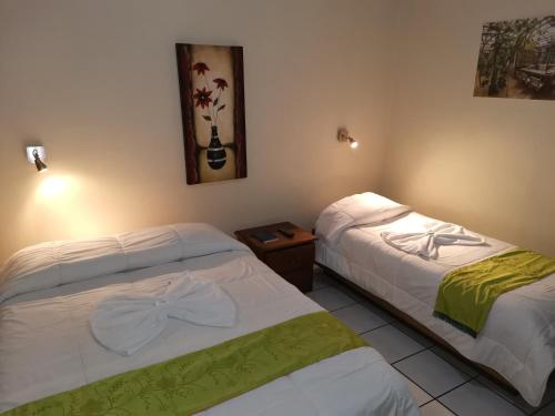 two beds sitting next to each other in a room at Hotel Wagelia Turrialba in Turrialba