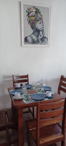 a wooden table with chairs and a picture of a woman at Pousada Neptun in Conde
