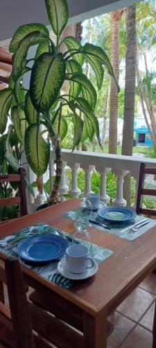 una mesa de madera con placas azules y blancas y una planta en Pousada Neptun en Conde