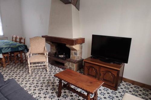 sala de estar con TV y chimenea en maison de ville pour 6 personnes, en Montdidier