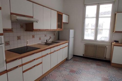 a kitchen with a sink and a refrigerator at maison de ville pour 6 personnes in Montdidier