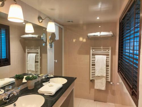baño con 2 lavabos y espejo grande en Logis HOTEL RESTAURANT La Régence en Cherbourg en Cotentin