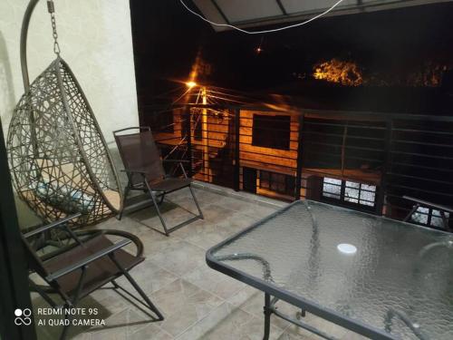 Un balcón con sillas, una mesa y una hamaca. en HERMOSO APARTAMENTO CON TERRAZA, en Ibagué