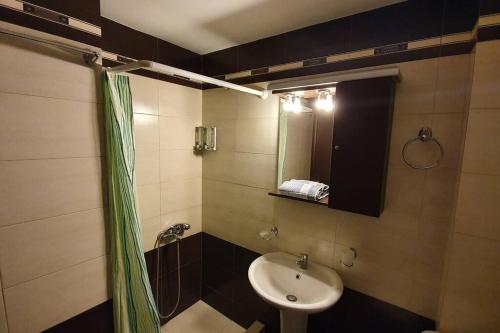 W łazience znajduje się umywalka i lustro. w obiekcie Angel Apartment w mieście Polijiros