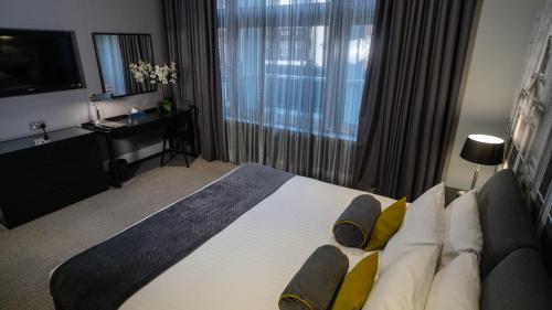 a hotel room with a large bed and a television at Grey Street Hotel in Newcastle upon Tyne