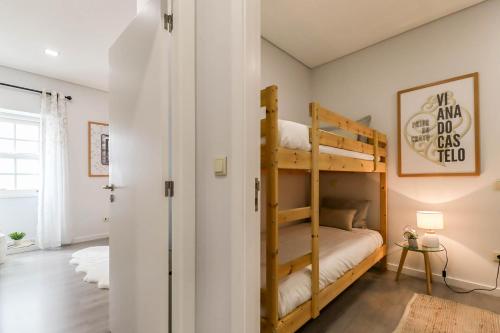 a bedroom with two bunk beds and a hallway at Viana Central - Historical City Centre Apartment in Viana do Castelo