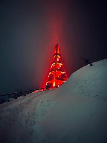 a lit up tower on top of a snow covered hill at Penzion pod Brehom in Terchová