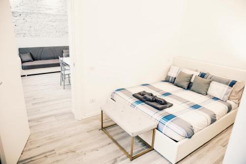 a white room with a bed and a table at Stazione-Centro Luminoso Bilocale in Brescia