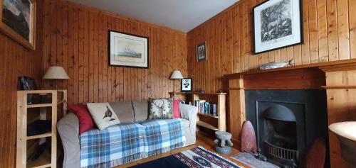 a living room with a couch and a fireplace at The Loan in Achiltibuie