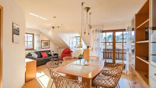 a dining room and living room with a table and chairs at Ferienwohnung Schmölzer in Roßhaupten