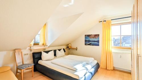 a small bedroom with a bed in a attic at Ferienwohnung Schmölzer in Roßhaupten