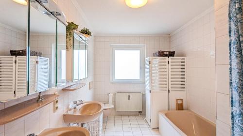 a bathroom with two sinks and a bath tub and a tubermott at Ferienbungalow Krahnke in Füssen